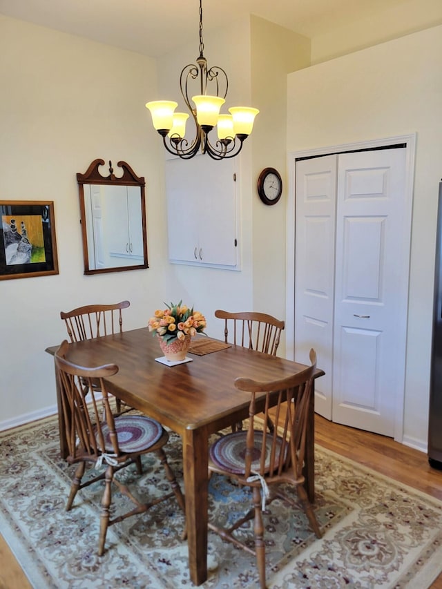 166 Long Rapids Rd, Alpena, MI 49707 - dining area with a chandelier, light wood-style floors, and baseboards
