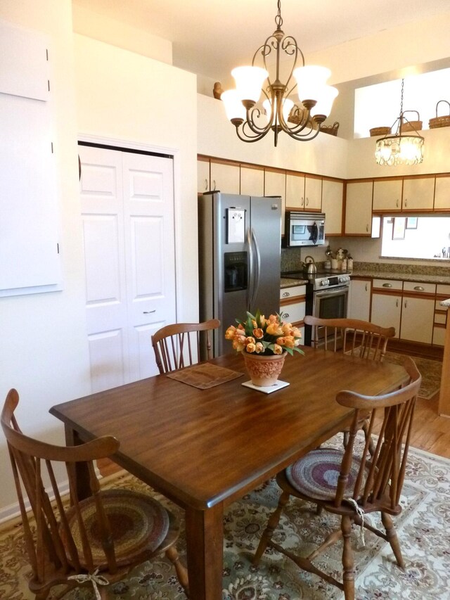 166 Long Rapids Rd, Alpena, MI 49707 - dining space with a chandelier and light wood finished floors