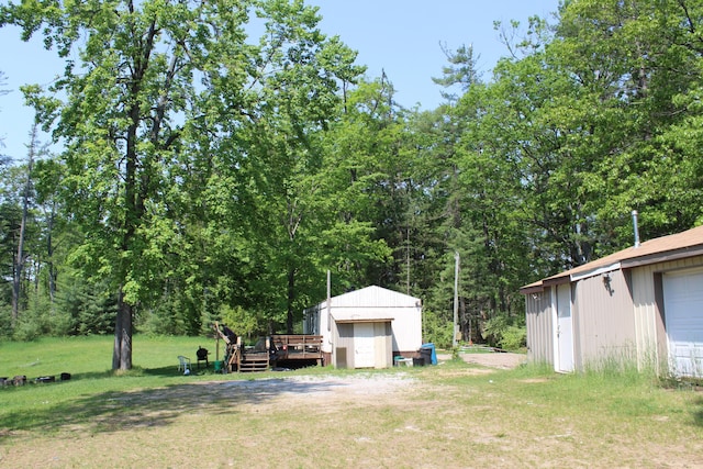 1864 Lenroy Valley Rd, Luzerne, MI 48636 - view of green lawn featuring an outbuilding and a deck