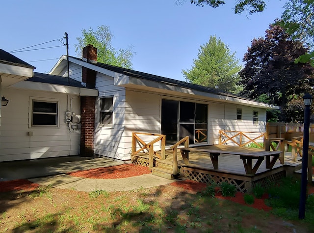 206 N Sixth St, Roscommon, MI 48653 - rear view of house with a chimney and a deck