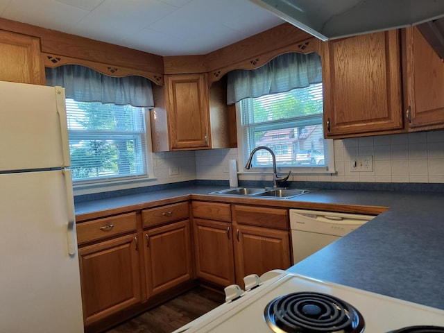 206 N Sixth St, Roscommon, MI 48653 - kitchen with white appliances, a sink, brown cabinets, dark countertops, and decorative backsplash