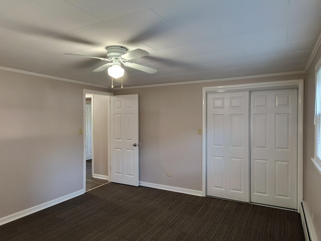206 N Sixth St, Roscommon, MI 48653 - unfurnished bedroom featuring a baseboard heating unit, dark carpet, a closet, baseboards, and crown molding