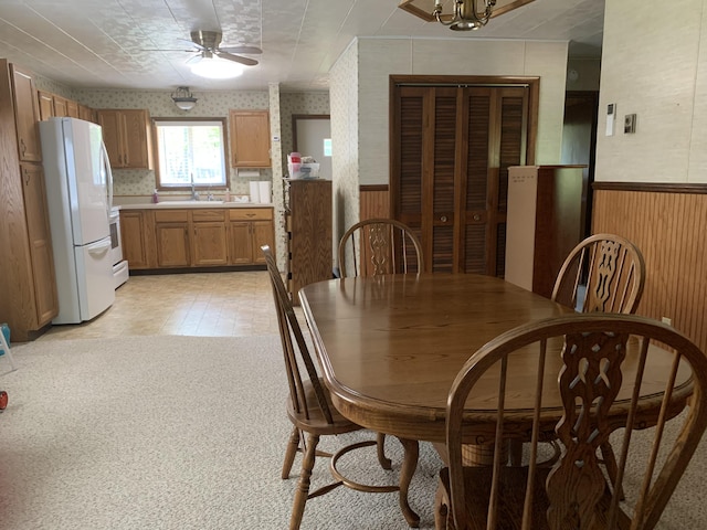14501 3rd St, Hubbard Lake, MI 49747 - dining area featuring a wainscoted wall, wallpapered walls, ceiling fan, and wood walls