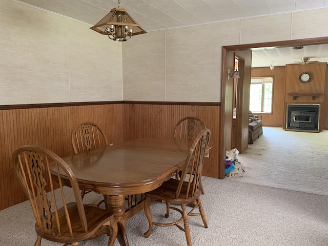 14501 3rd St, Hubbard Lake, MI 49747 - dining space featuring wood walls, carpet, a chandelier, a fireplace, and wainscoting