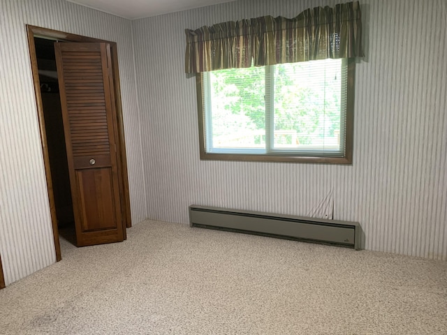 14501 3rd St, Hubbard Lake, MI 49747 - unfurnished bedroom featuring a baseboard radiator and carpet floors