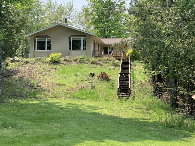 14501 3rd St, Hubbard Lake, MI 49747 - view of front facade with stairway, a front lawn, and a wooden deck
