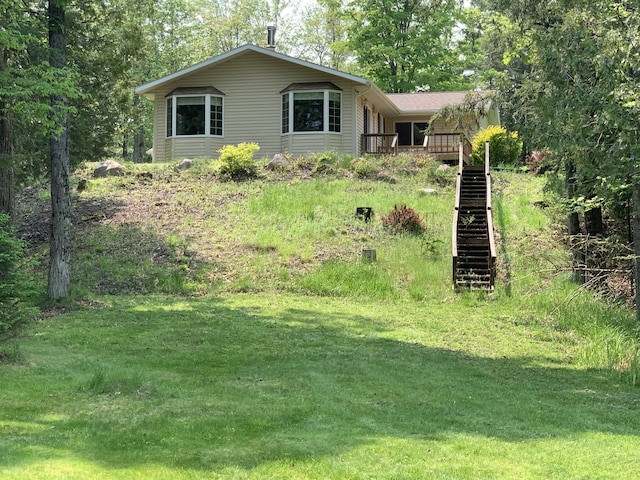 14501 3rd St, Hubbard Lake, MI 49747 - view of front of home with a deck, stairway, and a front yard
