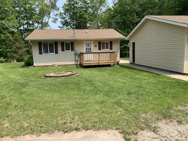 14501 3rd St, Hubbard Lake, MI 49747 - rear view of house with a wooden deck, a yard, and roof with shingles