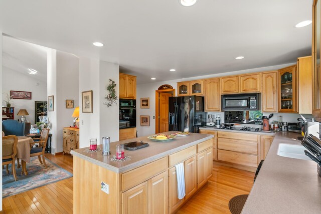 10077 Royal Coachman Trl, Gaylord, MI 49735 - kitchen featuring black appliances, light wood-style floors, a kitchen island, glass insert cabinets, and recessed lighting