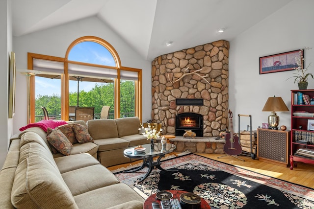 10077 Royal Coachman Trl, Gaylord, MI 49735 - living room with lofted ceiling, wood finished floors, and a stone fireplace