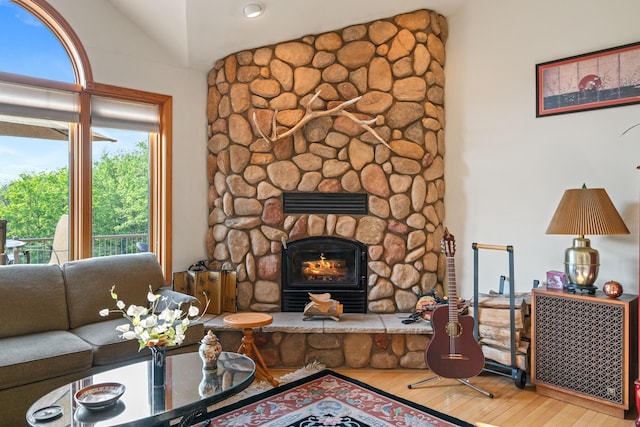 10077 Royal Coachman Trl, Gaylord, MI 49735 - living room with vaulted ceiling, wood finished floors, and a fireplace