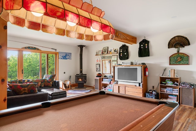 10077 Royal Coachman Trl, Gaylord, MI 49735 - recreation room featuring a wood stove, wood finished floors, and billiards table