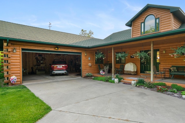 10077 Royal Coachman Trl, Gaylord, MI 49735 - view of front of home with covered porch, a garage, driveway, and log exterior