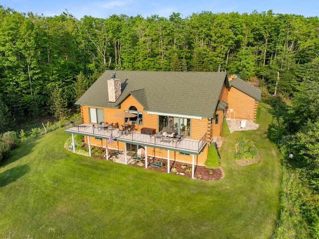 10077 Royal Coachman Trl, Gaylord, MI 49735 - rear view of house with a wooden deck, a view of trees, and a yard