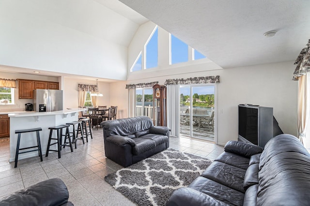 10480 N Straits Hwy, Cheboygan, MI 49721 - living room with a chandelier, high vaulted ceiling, and light tile patterned floors