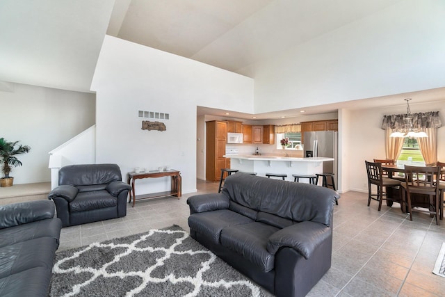 10480 N Straits Hwy, Cheboygan, MI 49721 - living room featuring light tile patterned floors, high vaulted ceiling, plenty of natural light, and a chandelier