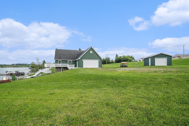 10480 N Straits Hwy, Cheboygan, MI 49721 - view of grassy yard featuring a water view, a detached garage, stairs, and an outbuilding