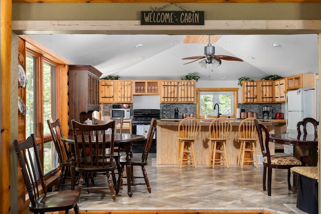 5466 Big Wolf Ln, Lewiston, MI 49756 - kitchen with vaulted ceiling, tasteful backsplash, a kitchen breakfast bar, black range with gas cooktop, and a ceiling fan