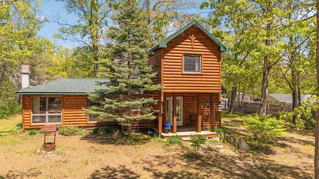 5466 Big Wolf Ln, Lewiston, MI 49756 - rear view of house with log veneer siding, a chimney, and a shingled roof