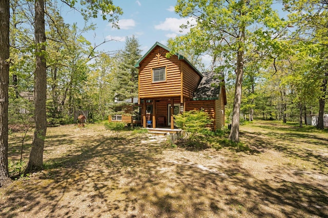 5466 Big Wolf Ln, Lewiston, MI 49756 - back of house with faux log siding and a porch