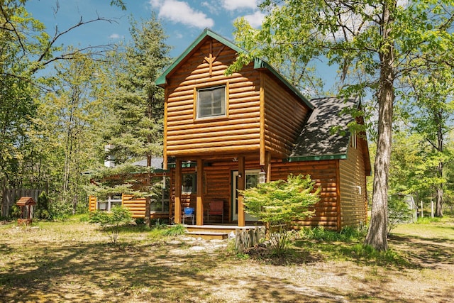 5466 Big Wolf Ln, Lewiston, MI 49756 - view of front facade with faux log siding and a porch