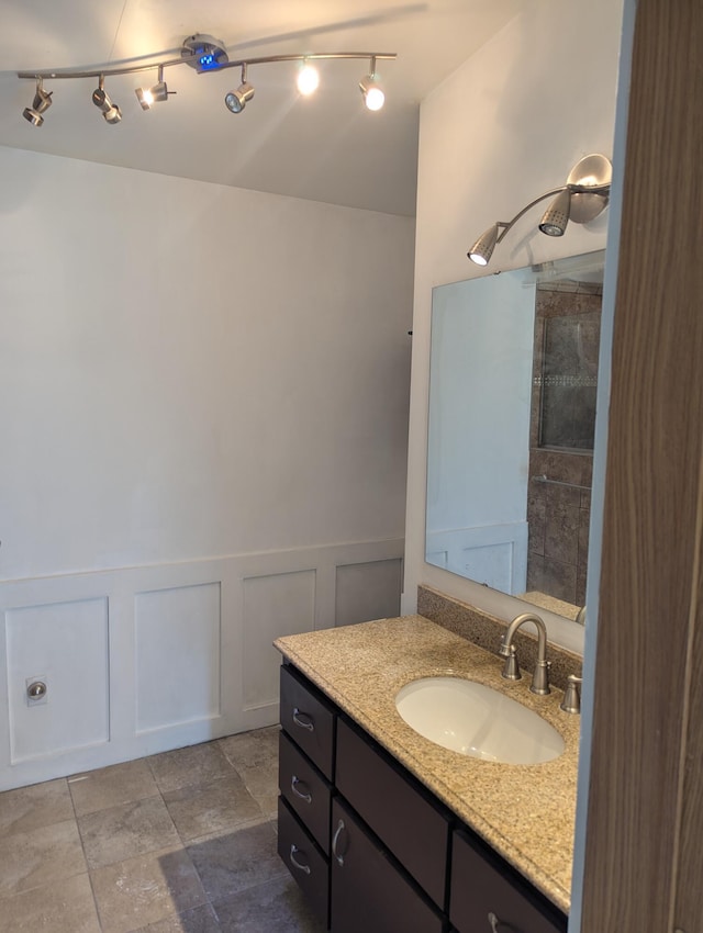 7322 E Grand Lake Rd, Presque Isle, MI 49777 - full bathroom featuring vanity, a decorative wall, wainscoting, and tiled shower