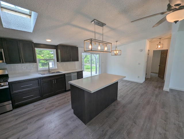 7322 E Grand Lake Rd, Presque Isle, MI 49777 - kitchen featuring stainless steel appliances, a textured ceiling, decorative backsplash, light countertops, and decorative light fixtures