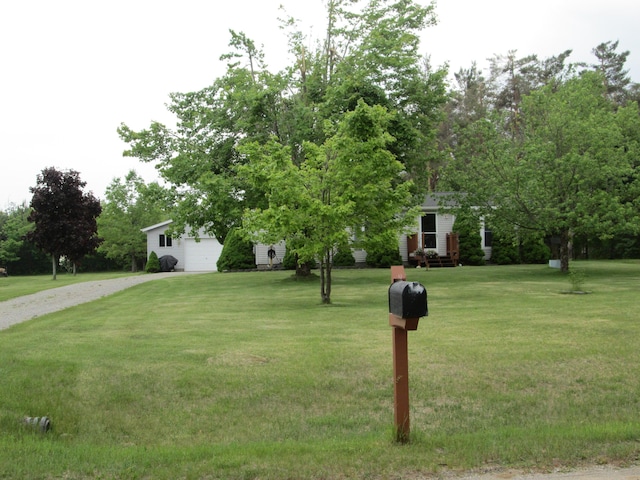5189 Pinecrest Dr, Lewiston, MI 49756 - view of property hidden behind natural elements featuring driveway, a front yard, and view of wooded area