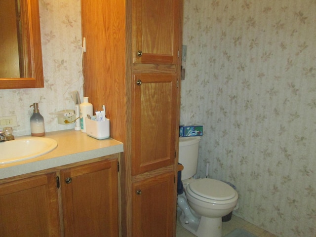5189 Pinecrest Dr, Lewiston, MI 49756 - half bathroom featuring wallpapered walls, vanity, and toilet