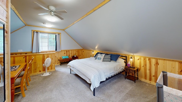 2303 Iroquois Ave, Prudenville, MI 48651 - carpeted bedroom with wooden walls, lofted ceiling, wainscoting, and ceiling fan