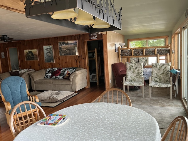 3606 S St, Lupton, MI 48635 - dining space featuring wood walls, ceiling fan, and wood finished floors