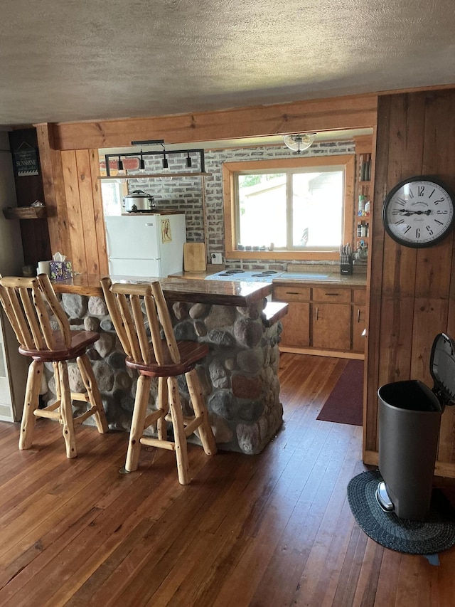 3606 S St, Lupton, MI 48635 - dining space featuring dark wood-style floors, a textured ceiling, and wooden walls