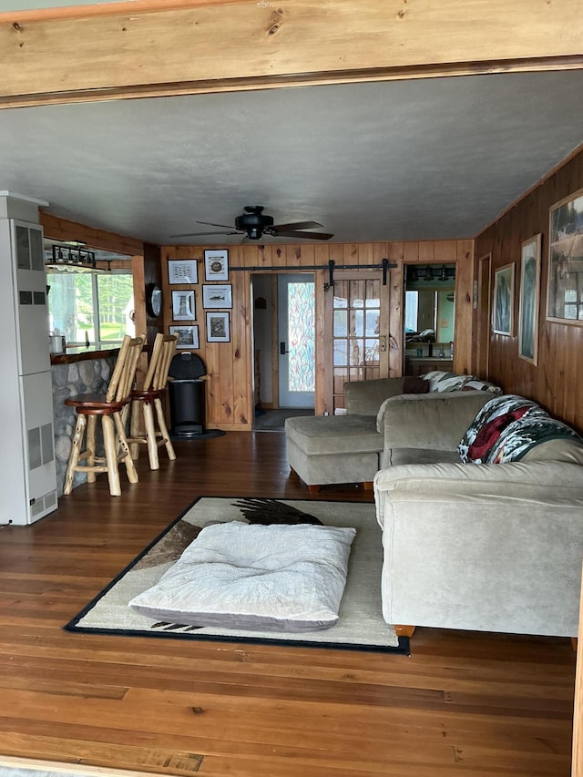 3606 S St, Lupton, MI 48635 - living room with wood walls, healthy amount of natural light, wood finished floors, and ceiling fan
