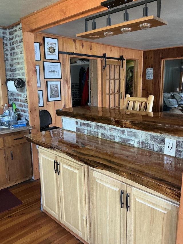 3606 S St, Lupton, MI 48635 - kitchen with wood walls, a barn door, and dark wood finished floors