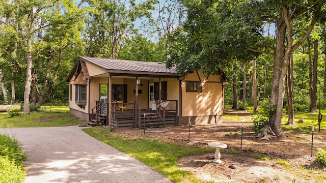 3065 E Dixon Lake Rd, Gaylord, MI 49735 - view of front facade featuring covered porch and a metal roof