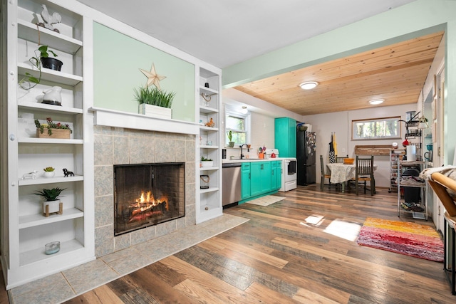 3065 E Dixon Lake Rd, Gaylord, MI 49735 - living area featuring a tile fireplace, dark wood finished floors, built in features, and wood ceiling