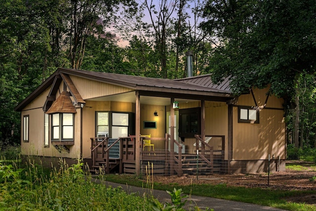 3065 E Dixon Lake Rd, Gaylord, MI 49735 - view of front of home featuring covered porch, a metal roof, and view of wooded area