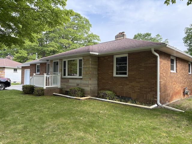 119 Kelly Rd, Alpena, MI 49707 - single story home with a front yard, a chimney, brick siding, a garage, and a shingled roof