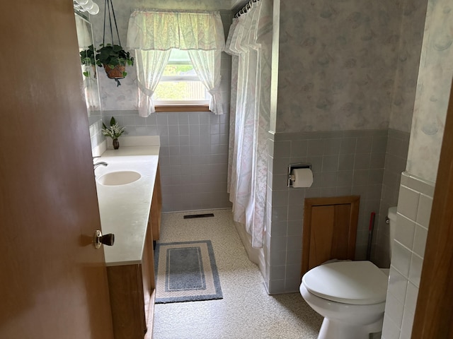 119 Kelly Rd, Alpena, MI 49707 - full bathroom with tile walls, toilet, vanity, wallpapered walls, and curtained shower