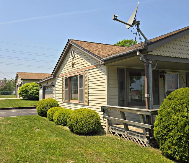 200 S 1st St, Saint Ignace, MI 49781 - view of property exterior featuring a lawn and a shingled roof