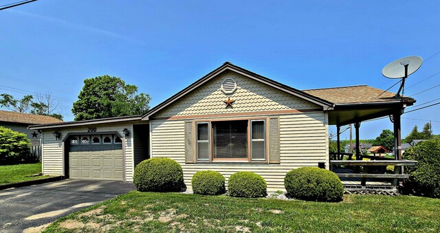 200 S 1st St, Saint Ignace, MI 49781 - victorian-style house with an attached garage, a front yard, and asphalt driveway