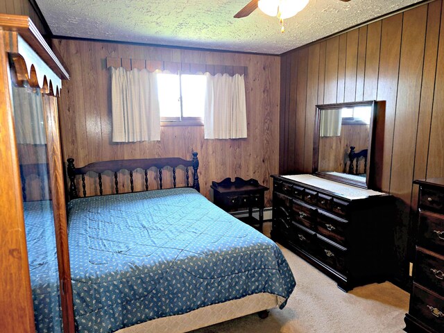 200 S 1st St, Saint Ignace, MI 49781 - bedroom featuring wooden walls, carpet, a textured ceiling, baseboard heating, and a ceiling fan
