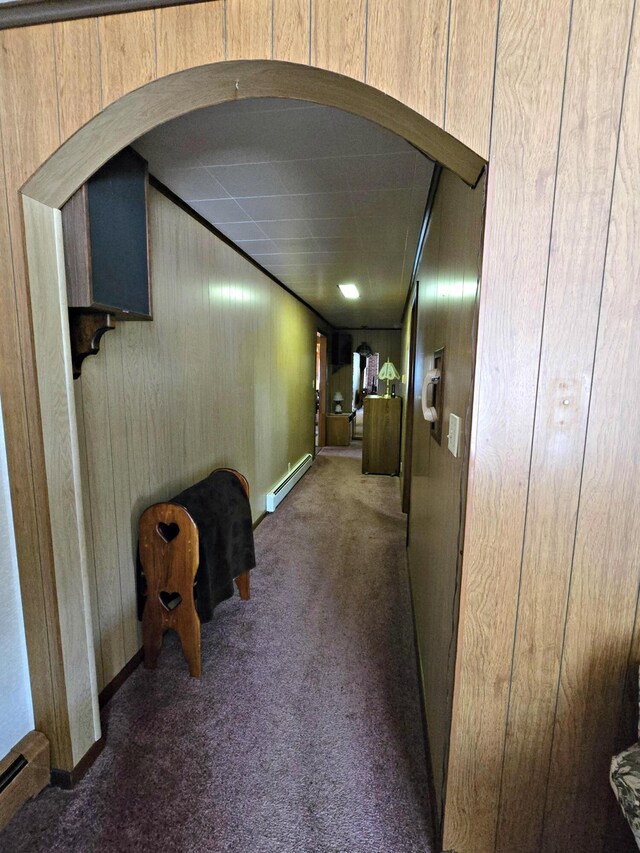 200 S 1st St, Saint Ignace, MI 49781 - hallway featuring a baseboard radiator, carpet flooring, wood walls, and arched walkways