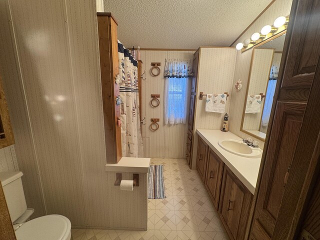 3981 Pointe Dr, Carp Lake, MI 49718 - full bathroom featuring toilet, a textured ceiling, tile patterned floors, vanity, and ornamental molding
