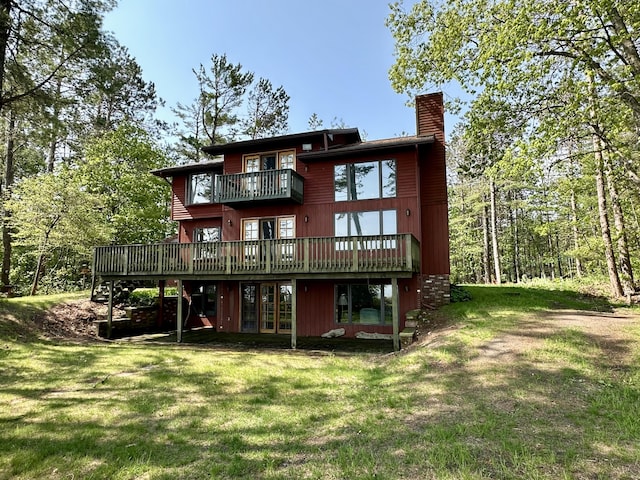 9561 Highbanks Dr, Cheboygan, MI 49721 - rear view of house with a chimney, a yard, a balcony, a wooden deck, and french doors