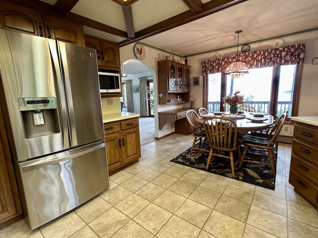 9561 Highbanks Dr, Cheboygan, MI 49721 - dining space featuring arched walkways, a chandelier, and beamed ceiling