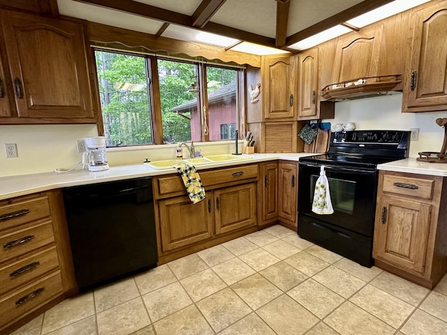 9561 Highbanks Dr, Cheboygan, MI 49721 - kitchen with black appliances, light countertops, brown cabinetry, under cabinet range hood, and light tile patterned floors