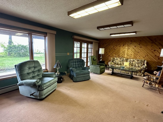 9561 Highbanks Dr, Cheboygan, MI 49721 - living room featuring carpet flooring, wooden walls, a textured ceiling, and a baseboard heating unit