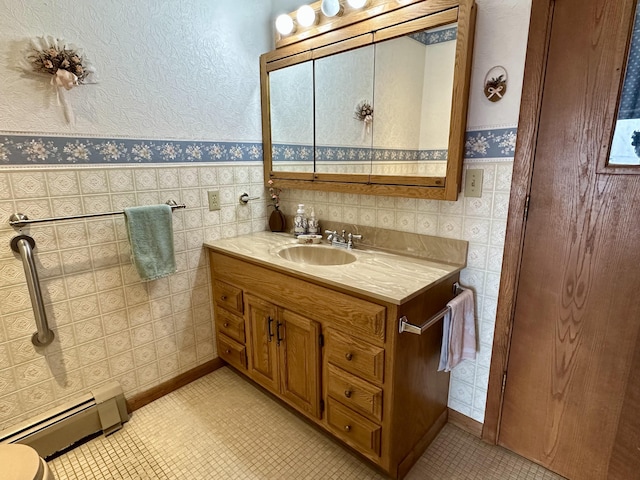 9561 Highbanks Dr, Cheboygan, MI 49721 - bathroom with a baseboard heating unit, vanity, wallpapered walls, a wainscoted wall, and tile walls