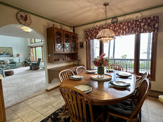 9561 Highbanks Dr, Cheboygan, MI 49721 - dining room featuring a chandelier, arched walkways, crown molding, light carpet, and light tile patterned floors